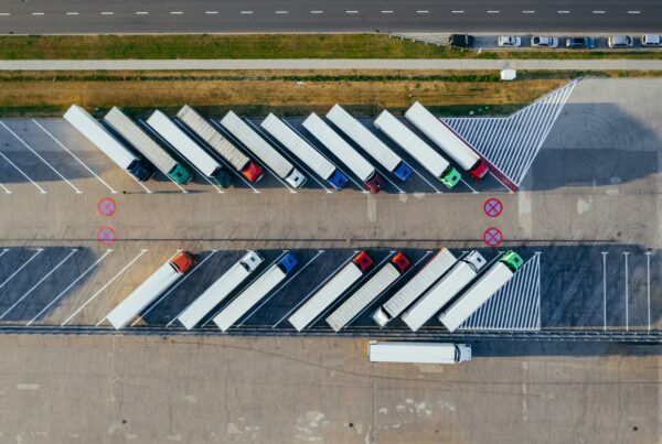 Aerial view of refrigerated trucks loading at a distribution facility, illustrating logistics and energy use in food supply chains